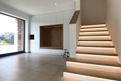 Moderne Betontreppe mit Holzbelag beleuchtete Stufen, Einbau-Garderobe - zwo ARCHITEKTEN