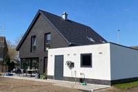 Neubau in Duisburg, modernes Einfamilienhaus mit Satteldach, Erdwärmepumpe, Glattziegel, farbige Dachüberstände, Eckfenster